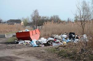 Garbage can is packed with garbage and waste. Untimely removal of garbage in populated areas photo