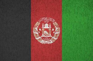 Afghanistan flag depicted in bright paint colors on old relief plastering wall. Textured banner on rough background photo