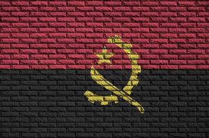 la bandera de angola está pintada en una vieja pared de ladrillos foto