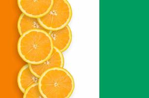 Ivory Coast flag and citrus fruit slices vertical row photo