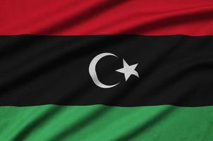 Libya flag is depicted on a sports cloth fabric with many folds. Sport team banner photo