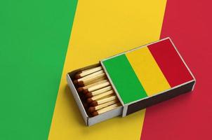 Mali flag is shown in an open matchbox, which is filled with matches and lies on a large flag photo