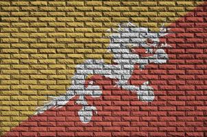 Bhutan flag is painted onto an old brick wall photo