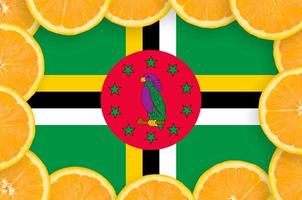 Dominica flag in fresh citrus fruit slices frame photo