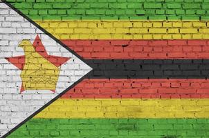 la bandera de zimbabwe está pintada en una vieja pared de ladrillos foto