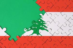 Lebanon flag is depicted on a completed jigsaw puzzle with free green copy space on the left side photo