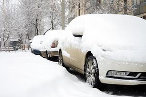 Fragment of the car under a layer of snow after a heavy snowfall. The body of the car is covered with white snow photo