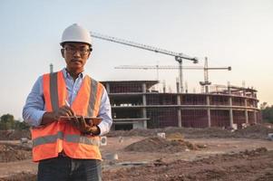 Asian engineer working at site of a large building project,Thailand people,Work overtime at construction site photo