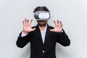 Portrait of young businessman wear virtual reality,VR goggles on white background photo