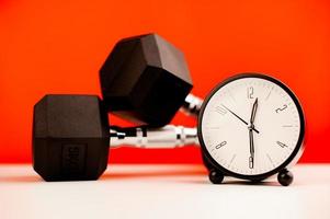 White clock and dumbbell time to set a workout schedule. time and exercise photo