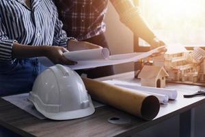 Construction engineer working at blueprint to build large commercial buildings in office. Engineering tools and construction concept. photo