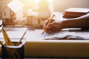 Construction engineer working at blueprint to build large commercial buildings in office. Engineering tools and construction concept. photo