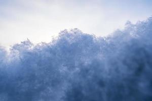 Fluffy snow against the sky, on a winter evening, at sunset. Copy space. Abstract background. Bottom view. photo