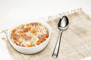 Fried rice with egg ham carrot in bowl isolated on white background photo