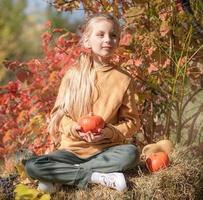 Girl in the hay with pumpkins photo