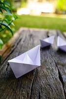 Origami, white paper boat isolated on a wooden floor.  Paper boats mean walking.  feeling of freedom  leadership photo