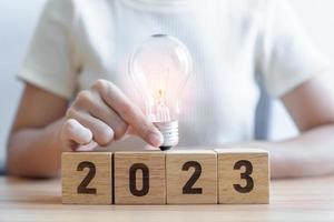 2023 block with lightbulb. Business Idea, Creative, Thinking, brainstorm, Goal, Resolution, strategy, plan, Action, change and New Year start concepts photo