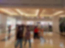 Defocused abstract background of in front of a mall with a lot of people shopping in the background photo