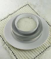 Bowl sand sugar on a pile of plates with white background photo