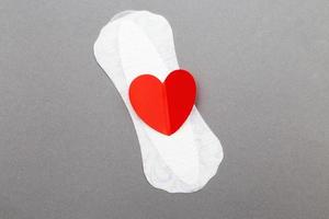 Feminine sanitary pad with a red heart on gray background