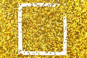 glittering background of golden sequins closeup. Sparkle festive texture. white frame for your text photo