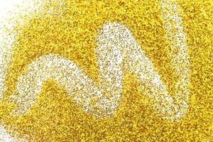 glittering background of golden sequins isolated on a white background closeup. Sparkle festive texture photo