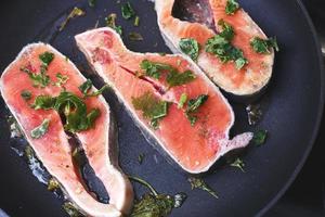 Raw trout steaks in frying pan, top view.