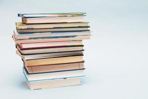 Stack of colorful books on blue background with copy space. Back to school concept. photo