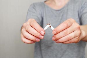 young woman holding broken cigarette in her hands close photo