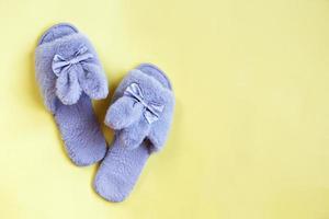 Pair of stylish soft slippers on yellow background, flat lay. copy space for text photo