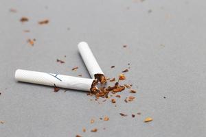 broken cigarette on gray background close. stop smoking concept photo