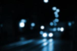 Blurred night scene of traffic on the roadway. Defocused image of cars traveling with luminous headlights. Bokeh Art photo