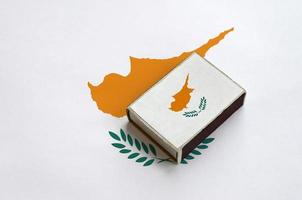 Cyprus flag is pictured on a matchbox that lies on a large flag photo