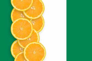 Nigeria flag and citrus fruit slices vertical row photo