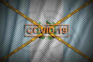 Guatemala flag and Covid-19 stamp with orange quarantine border tape cross. Coronavirus or 2019-nCov virus concept photo