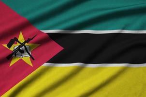 Mozambique flag is depicted on a sports cloth fabric with many folds. Sport team banner photo