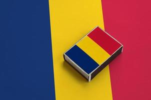 Chad flag is pictured on a matchbox that lies on a large flag photo