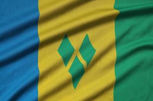 Saint Vincent and the Grenadines flag is depicted on a sports cloth fabric with many folds. Sport team banner photo