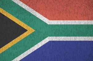 South Africa flag depicted in bright paint colors on old relief plastering wall. Textured banner on rough background photo