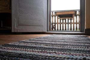 Open white door with access to the balcony, against a blurred background table. photo