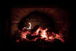 carbones humeantes en una estufa rusa retro tradicional, en una casa de pueblo. estilo de vida en el campo. foto