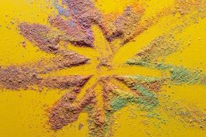 Bright star is drawn on a multicolored powder on a yellow background. Holiday concept. Beautiful postcard. Top view.