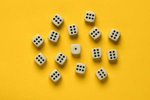 Dice on a yellow background, many sixes surrounded one unit. Top view. photo