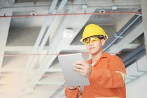 ingeniero o capataz sosteniendo una tableta. sitio de ingeniería de detalles de trabajo y trabajo con concepto de tecnología. foto