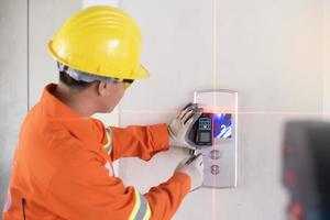 Worker Engineer uses a meter tape to measure values according to the laser level photo