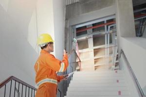 ingeniero o capataz sosteniendo una tableta. sitio de ingeniería de detalles de trabajo y trabajo con concepto de tecnología. foto