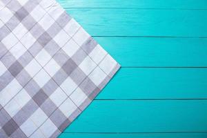 Grey plaid tablecloth on blue rustic wooden table, top view and copy space. Mock up and wood background. photo