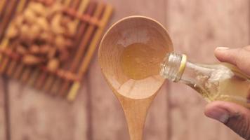 Overhead view pouring oil into wooden spoon video