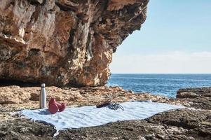 Fitness and sports concept background. Getting ready. Towel, jump rope, dumbbell and bottle of water, by the sea on a sunny winter day, with beautiful blue sky photo