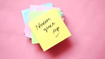 Never give up note on pile of colorful sticky notes video